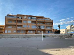 un edificio con una pista de tenis delante en Beachfront and Peaceful Apartment, en Mareny Barraquetas