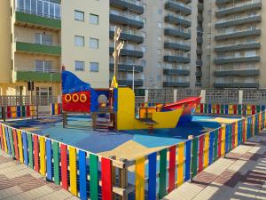 einen Spielplatz vor einem großen Gebäude in der Unterkunft Beachfront and Peaceful Apartment in Mareny Barraquetas