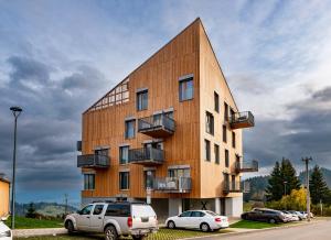 a building with cars parked in front of it at CARI APARTMENTS, Hillside in Dolný Kubín