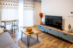 sala de estar con sofá y TV en CARI APARTMENTS, Hillside, en Dolný Kubín