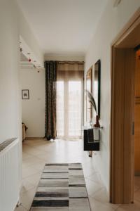 a hallway with a large window and a rug at DimSim Home-Σπίτι με όνομα in Tríkala