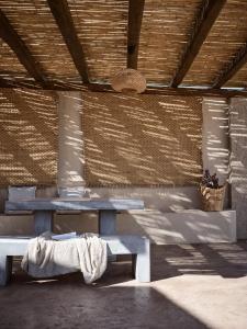 a picnic table in the shade of a building at Seaside Luxury LaTerre, Zante Zen By ThinkVilla in Psarou