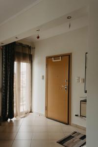 ein leeres Zimmer mit einer Tür und einem Fenster in der Unterkunft DimSim Home-Σπίτι με όνομα in Tríkala