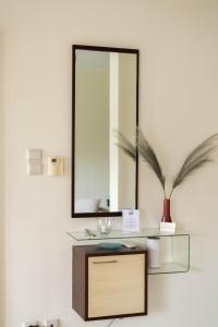 a mirror on a wall next to a desk with a plant at DimSim Home-Σπίτι με όνομα in Tríkala