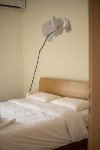 sypialnia z łóżkiem z kwiatem na ścianie w obiekcie DimSim Home-Σπίτι με όνομα w mieście Tríkala