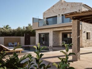 a house with a glass facade with a swimming pool at LaTerre Villa, Zante Zen By ThinkVilla in Psarou