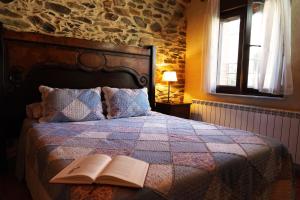 a bedroom with a bed with an open book on it at Los Monteros Sierra de Francia in Aldeanueva de la Sierra