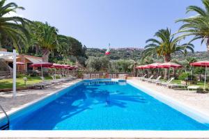 a swimming pool with chairs and umbrellas at a resort at Country Hotel Residence Da Pilade in Capoliveri