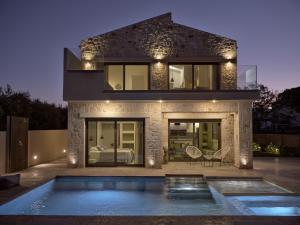 a house with a swimming pool in front of it at LaTerre Villa, Zante Zen By ThinkVilla in Psarou