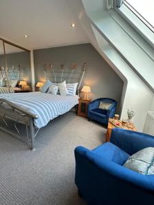 a bedroom with a bed and a blue couch at Tarskavaig Bed & Breakfast in Radernie
