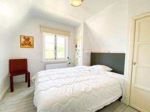 Un dormitorio blanco con una cama grande y una ventana en Villa La Pastourelle - Cozy vacation house en Koksijde