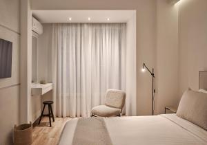 sypialnia z łóżkiem, krzesłem i oknem w obiekcie Cute n Comfort Luxury Condo in Kolonaki w Atenach