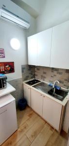 eine Küche mit weißen Schränken und einem Waschbecken in der Unterkunft room n.23 in Taranto