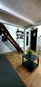 ein Wohnzimmer mit einem Tisch und einer Treppe in der Unterkunft room n.23 in Taranto