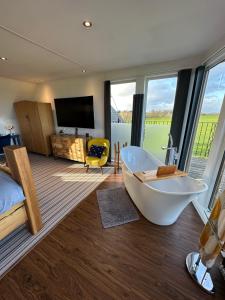 uma grande casa de banho com banheira e televisão em Tarskavaig Bed & Breakfast em Radernie