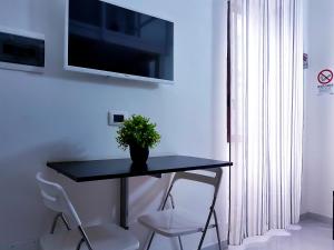 a black table with two chairs and a plant on it at room n.23 in Taranto