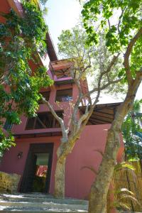 a pink house with trees in front of it at Biancas Garden Apartments Boracay in Boracay