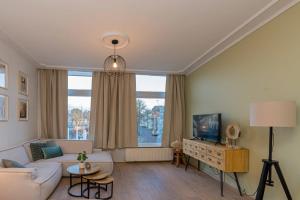 a living room with a couch and a tv at Twee Wijzen in Zierikzee