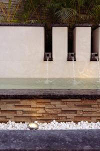 a pool with two water fountains at The Greenwood Guwahati - A Luxury Boutique Hotel in Guwahati
