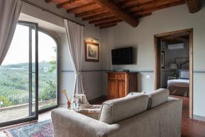 a living room with a couch and a large window at Relais Villa Olmo in Impruneta