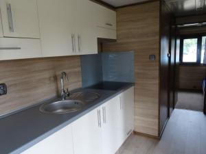 a kitchen with a sink and white cabinets at Sopot 34 przy plaży in Sopot