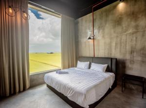 a bedroom with a large bed with a large window at PADI Sentral @ Sekinchan in Sekincan