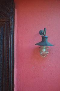 a light on the side of a red wall at Biancas Garden Apartments Boracay in Boracay