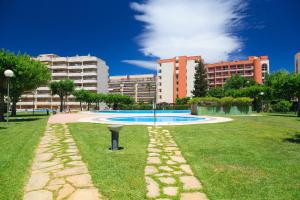 a swimming pool in a park with buildings in the background at UHC Jerez Cordoba Sevilla Apartments in Salou