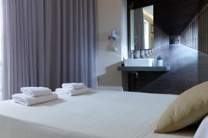 a bedroom with a large white bed with towels on it at Prime Room in Heraklion Center in Heraklio