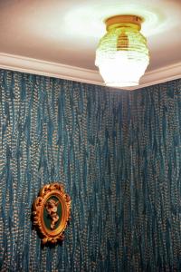 a mirror on a wall with blue wallpaper at Sunny ap in the citycentre in Budapest