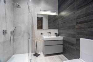 a bathroom with a sink and a shower at Tyzenhauz Apartments Superior in Krakow