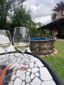 two glasses of white wine sitting on a table at Residencia en Casa de artista in Vistalba