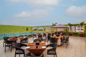 a restaurant with tables and chairs on a patio at Sterling V Grand Madurai in Madurai