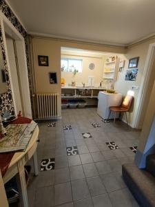 a kitchen with a tiled floor with a table and refrigerator at Arsalir Guesthouse Vik B&B in Vík