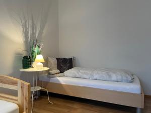 a bedroom with a bed with a lamp and a table at Allgäutraum Ferienwohnung Nr. 1 in Kempten