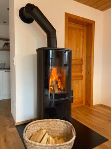 a stove with a fire in a room with a basket at Ferienwohnung Hofleben Reiner in Neukirchen vorm Wald