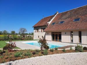 a house with a swimming pool next to a building at Domaine du moulin de Jeanne in Courlaoux