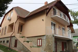 a house with a staircase leading up to it at Lenke Apartmanház in Balatonlelle