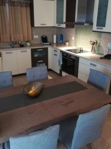 a kitchen with a wooden table with chairs around it at SUNSENSES Villa in Angairiá