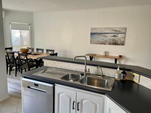a kitchen with a sink and a table with chairs at McCracken Homestay in McCracken