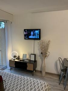 ein Wohnzimmer mit einem TV an einer weißen Wand in der Unterkunft Apartment Eden Park in Saint-Tropez