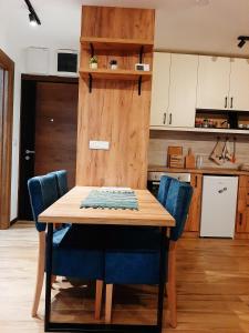 a kitchen with a wooden table and blue chairs at Pahulja in Divčibare
