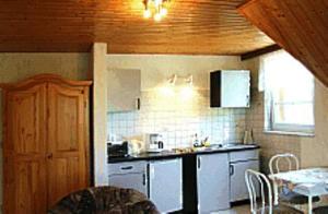 a kitchen with white cabinets and a table in it at Pension Fröhlich in Gager
