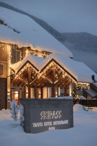 ein Hotel mit einem Schild im Schnee in der Unterkunft Boutique Skipass Superior Hotel in Kranjska Gora