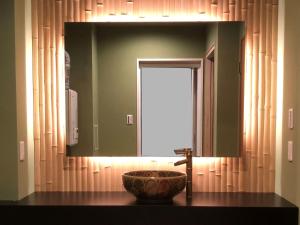 La salle de bains est pourvue d'un lavabo et d'un grand miroir. dans l'établissement Osaka Ukiyoe Ryokan, à Osaka