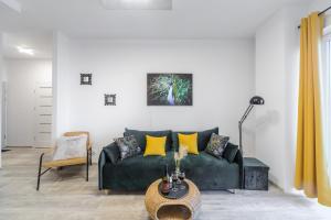 a living room with a green couch and yellow pillows at Lumina 2-room apartments with parking Lodz in Łódź