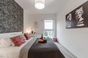 Un dormitorio con una cama grande y una mesa. en Lumina 2-room apartments with parking Lodz en Lodz