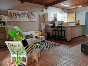 a living room with a couch and a kitchen at The Homestay in Nelspruit