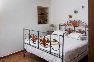 ein Schlafzimmer mit einem Metallbett mit weißen Laken und Kissen in der Unterkunft Cottage home at South Chania in Grigorianá