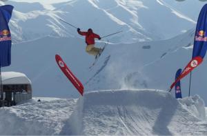 a person jumping off a ramp on skis in the snow at Luxury hotel room with amazing views in Gudauri